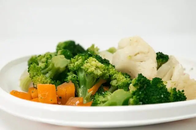 afvallen zonder dieet kan als je gezond gaat eten met brocolli, wortels en bloemkool op een wit bord