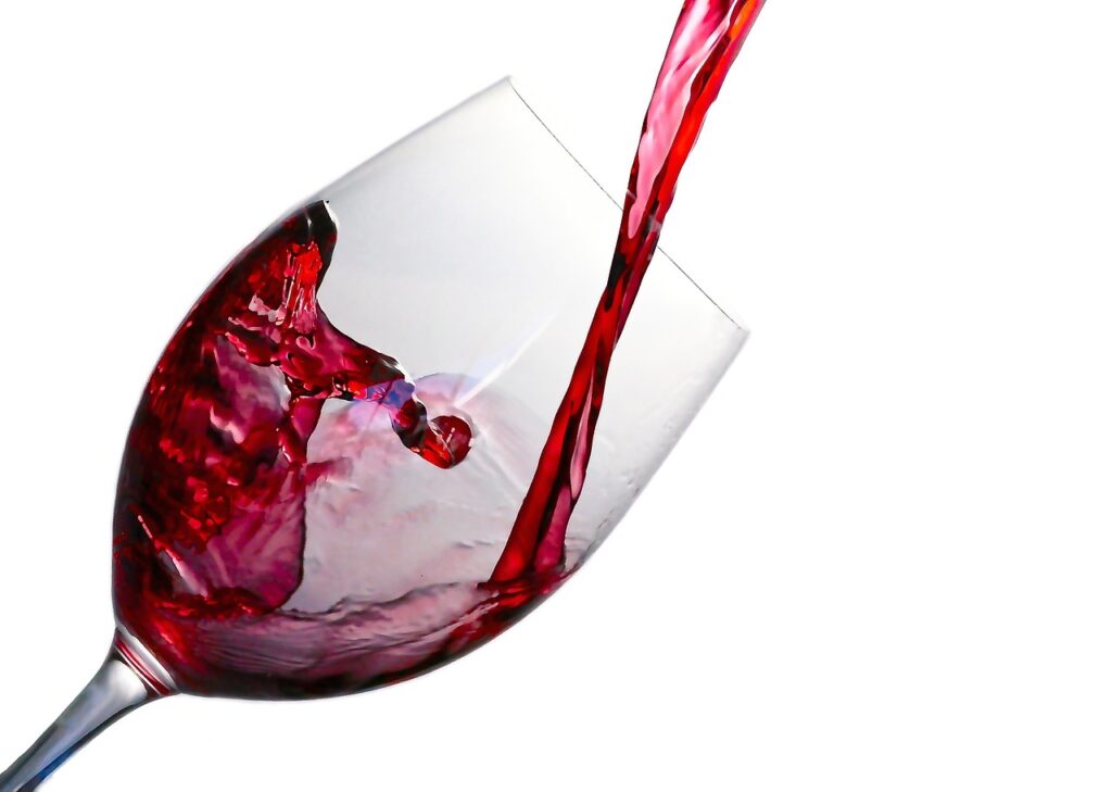 Een glas rode wijn die wordt ingeschonken.