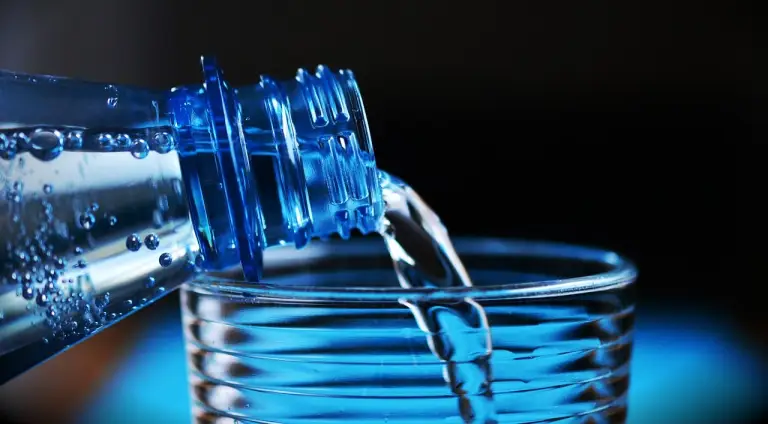 water uit een flesje wordt in een glas geschonken. metabolisme versnellen.