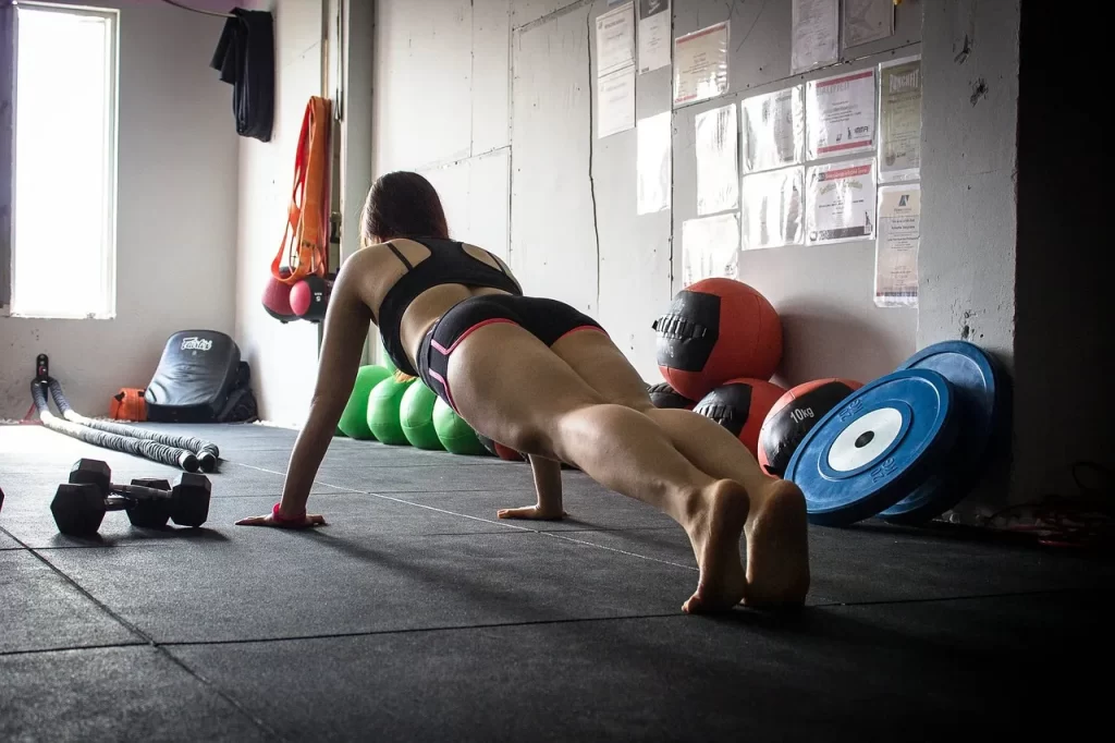 vrouw doet oefeingen in een gym, met gewichten, kettlebells en dergelijke