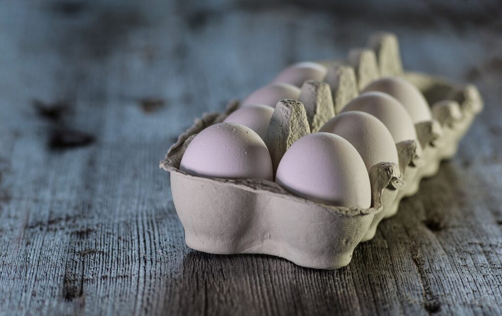 eieren in een eierdoos op een steigerhouten tafel . afvallen met eieren