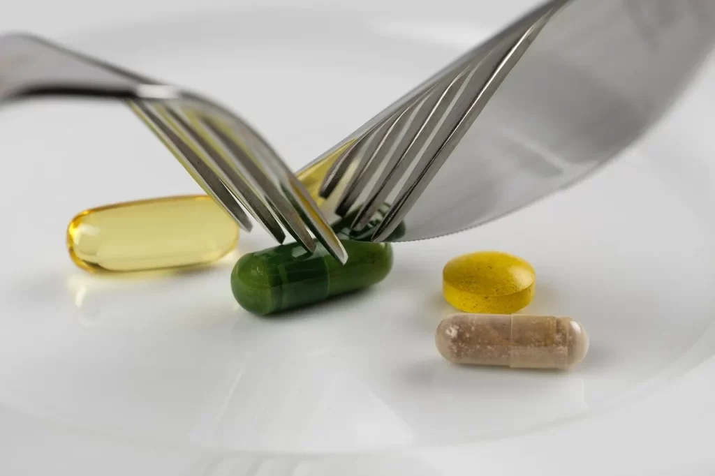 pillen tabletten en capsules die worden aangesneden met een een mes en vork. snel afvallen