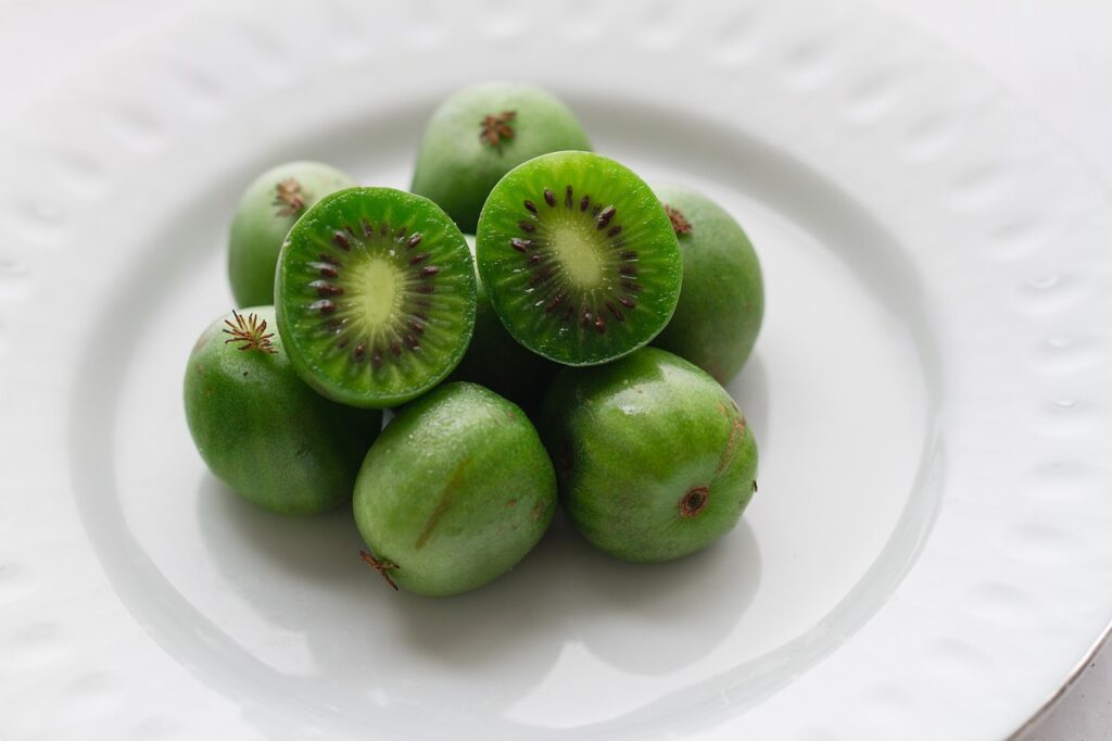 kiwi's en granaatappels op een wit bord